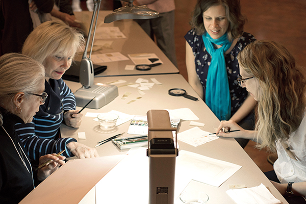 <p>Sharon Arffa, Assistant Librarian Jeannette McDevitt and Assistant Curator of Art Carrie Roy practice painting on vellum with artist Wendy Brockman, 20 March 2015, photo by Frank A. Reynolds, reproduced by permission of the photographer.</p>